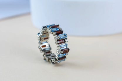 Multi gemstone baguette eternity ring with garnet and Swiss blue topaz in 925 silver
