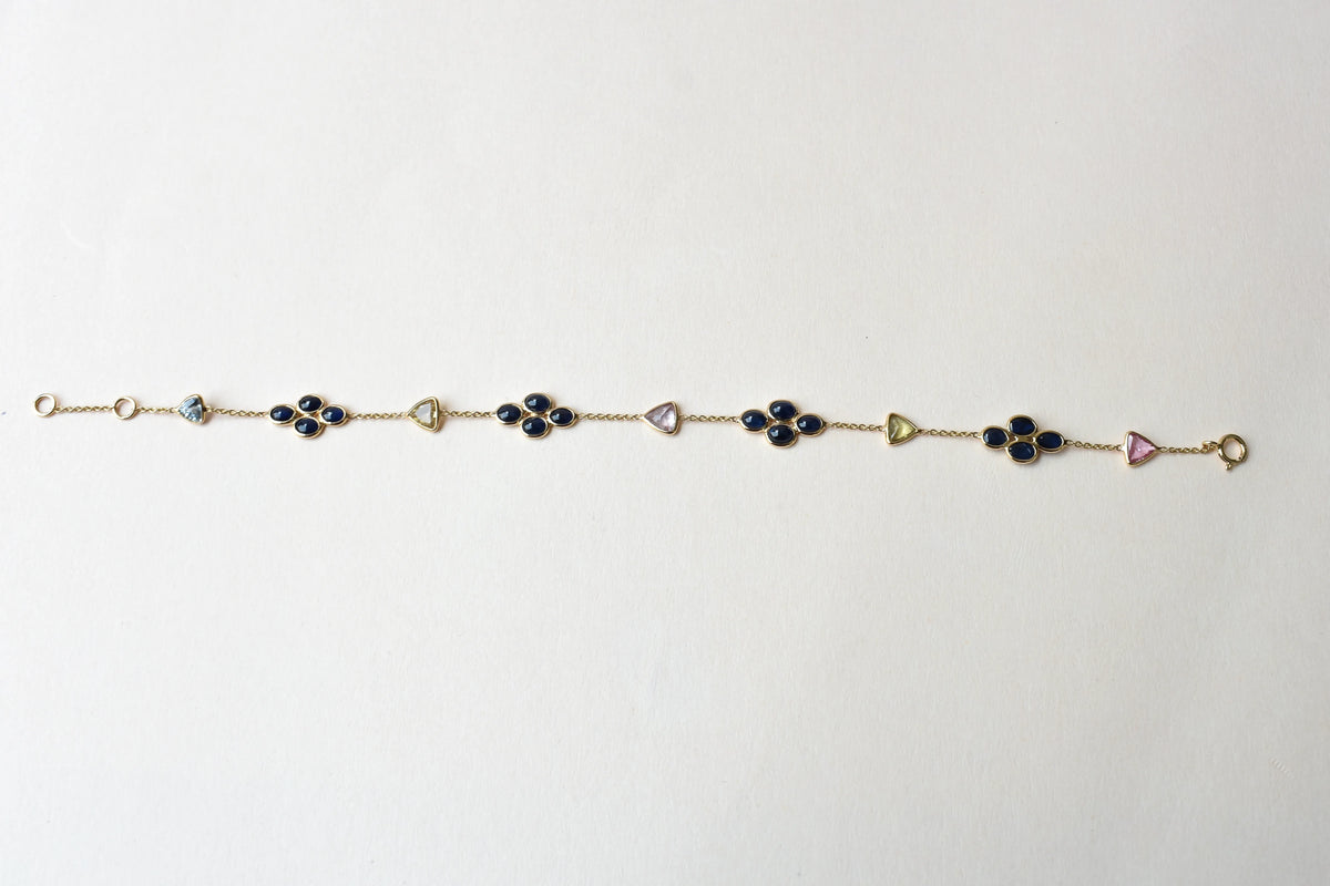 18K gold bracelet with blue sapphire clusters and multi-color trillion sapphire accents