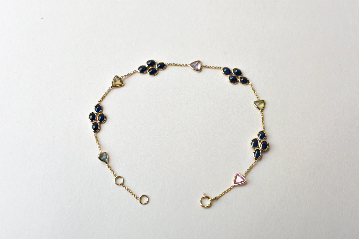 18K gold bracelet with blue sapphire clusters and multi-color trillion sapphire accents