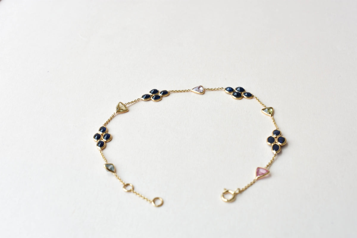 18K gold bracelet with blue sapphire clusters and multi-color trillion sapphire accents
