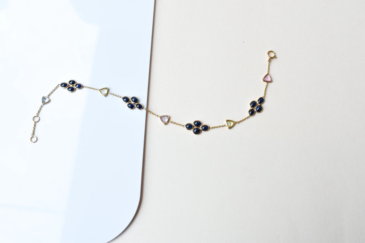 18K gold bracelet with blue sapphire clusters and multi-color trillion sapphire accents
