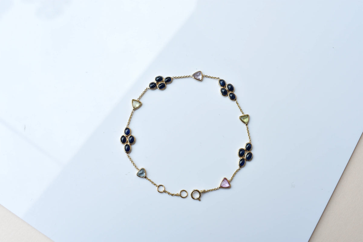 18K gold bracelet with blue sapphire clusters and multi-color trillion sapphire accents