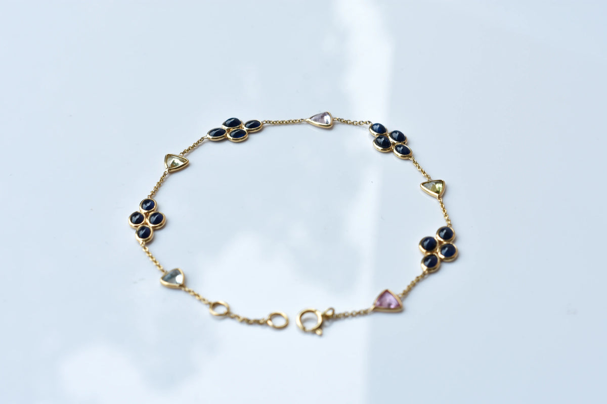 18K gold bracelet with blue sapphire clusters and multi-color trillion sapphire accents