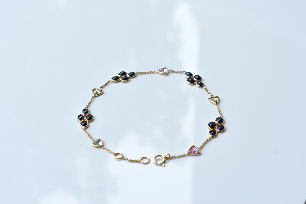 18K gold bracelet with blue sapphire clusters and multi-color trillion sapphire accents