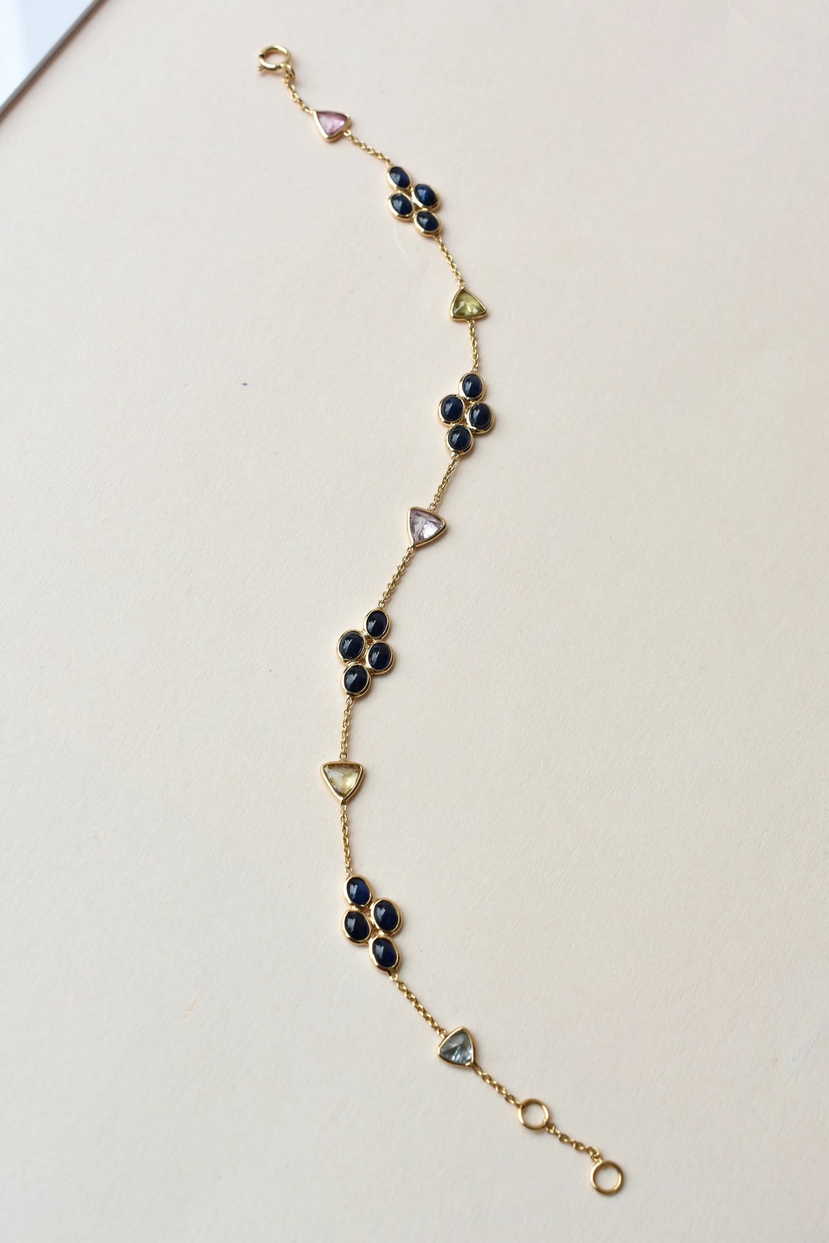 18K gold bracelet with blue sapphire clusters and multi-color trillion sapphire accents