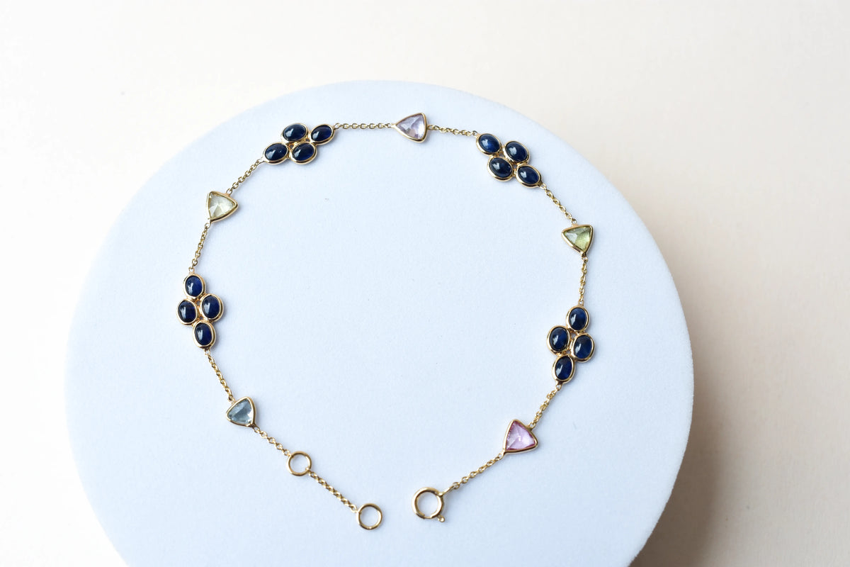 18K gold bracelet with blue sapphire clusters and multi-color trillion sapphire accents