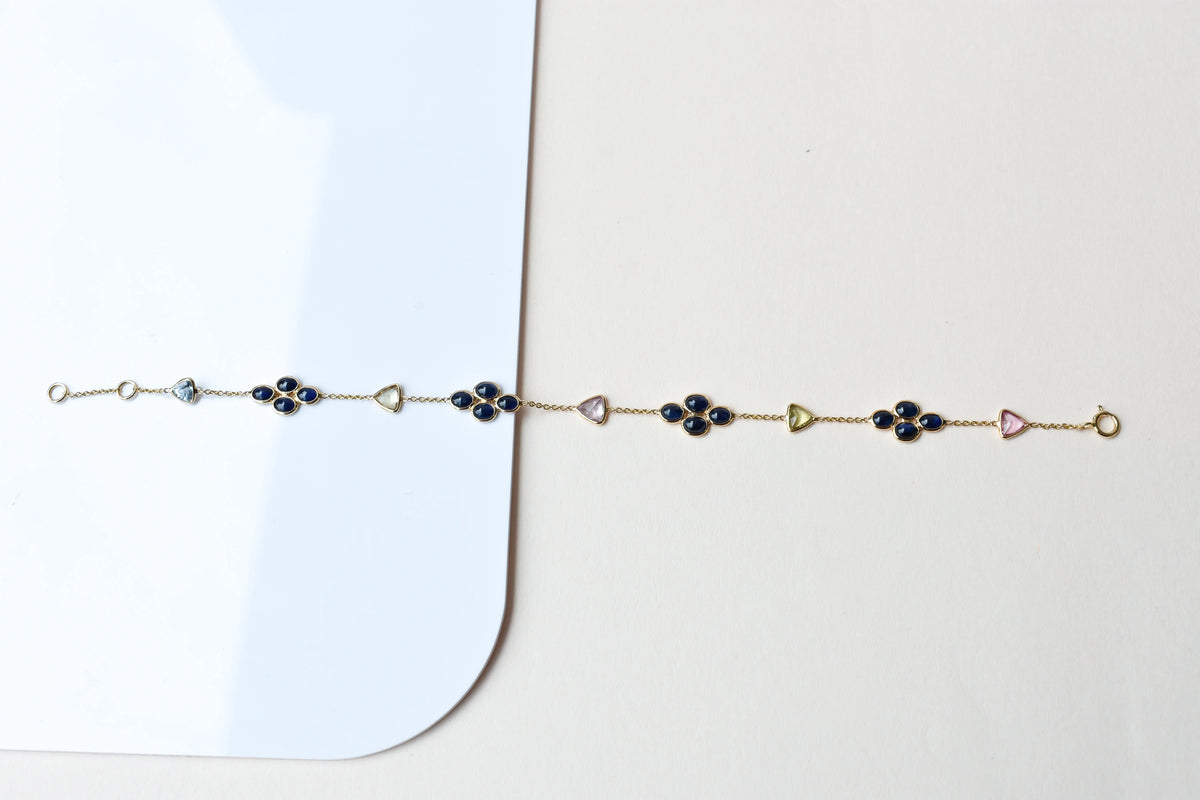 18K gold bracelet with blue sapphire clusters and multi-color trillion sapphire accents