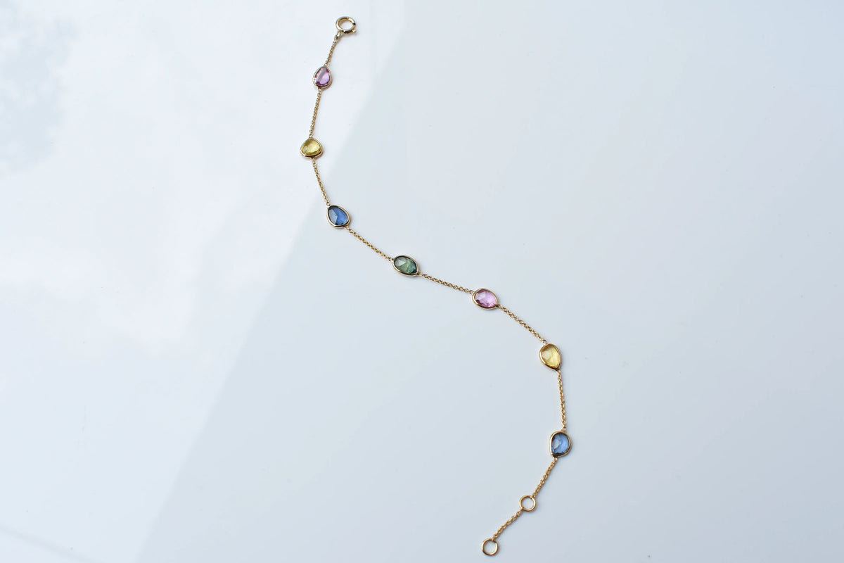 18K gold bracelet with single oval multi-color sapphire stations