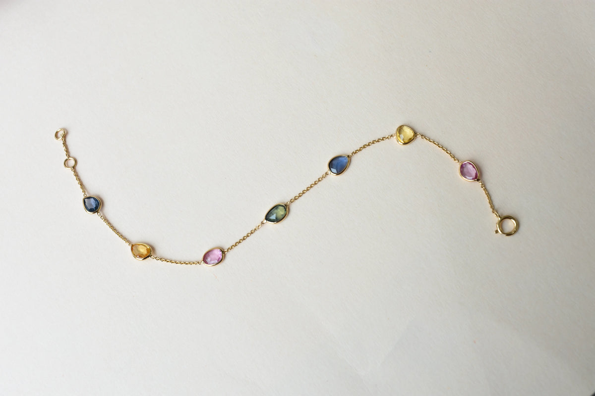 18K gold bracelet with single oval multi-color sapphire stations