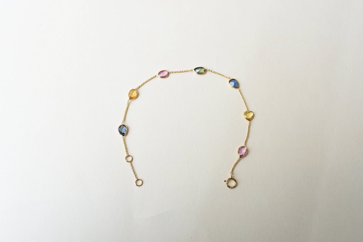 18K gold bracelet with single oval multi-color sapphire stations