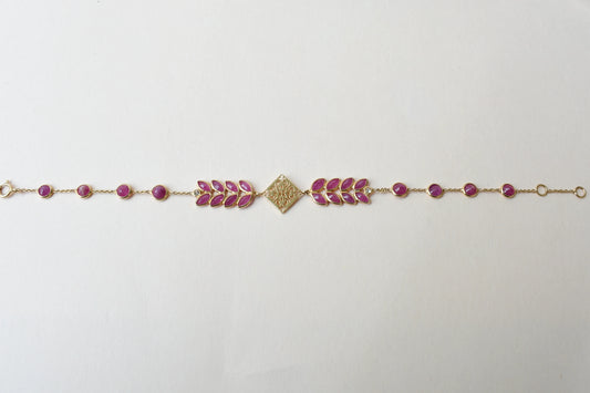 18K gold bracelet with round ruby stations and a diamond accent