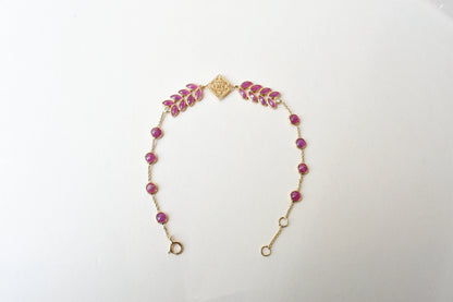 18K gold bracelet with round ruby stations and a diamond accent