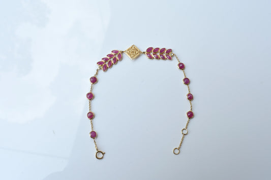 18K gold bracelet with round ruby stations and a diamond accent