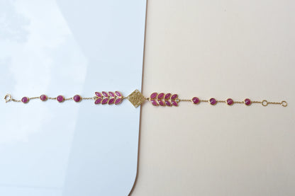 18K gold bracelet with round ruby stations and a diamond accent