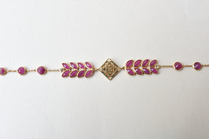 18K gold bracelet with round ruby stations and a diamond accent