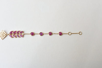 18K gold bracelet with round ruby stations and a diamond accent