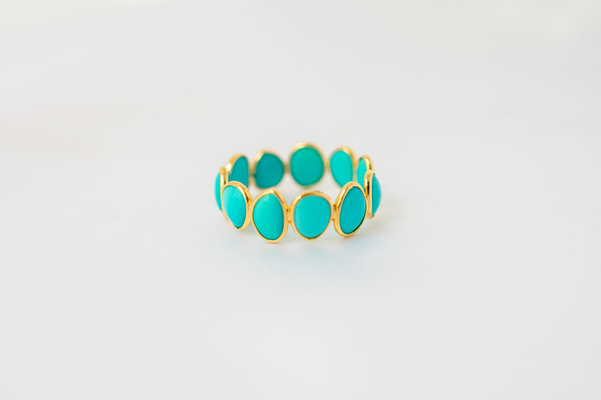 Oval cabochon turquoise gemstone eternity ring in gold with bezel setting