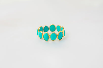 Oval cabochon turquoise gemstone eternity ring in gold with bezel setting