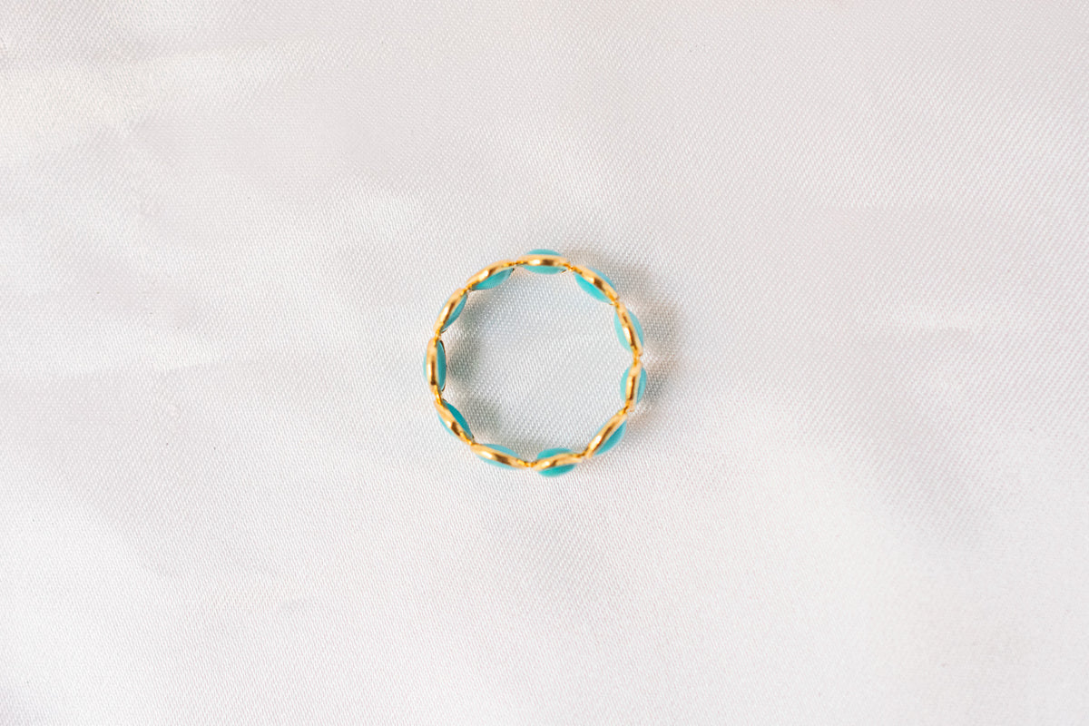 Oval cabochon turquoise gemstone eternity ring in gold with bezel setting