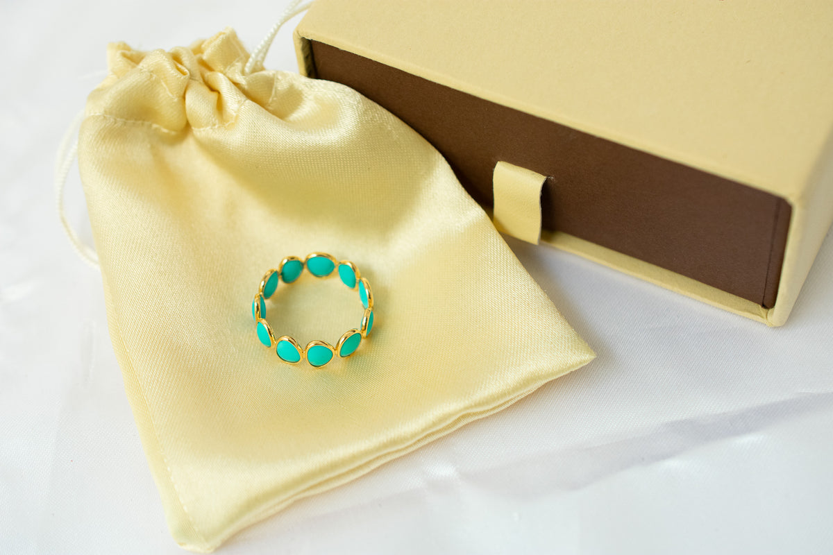 Oval cabochon turquoise gemstone eternity ring in gold with bezel setting