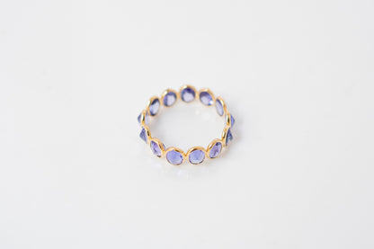Oval-cut tanzanite gemstone eternity ring in 18K gold with bezel setting