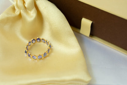 Oval-cut tanzanite gemstone eternity ring in 18K gold with bezel setting