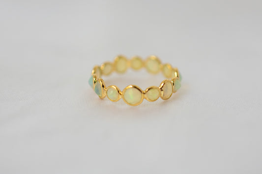 Cabochon opal gemstone eternity ring in 18K gold with bezel setting