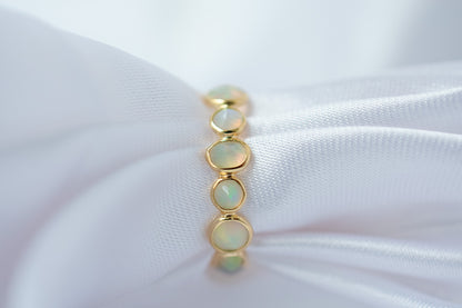 Cabochon opal gemstone eternity ring in 18K gold with bezel setting