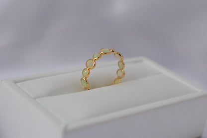 Cabochon opal gemstone eternity ring in 18K gold with bezel setting