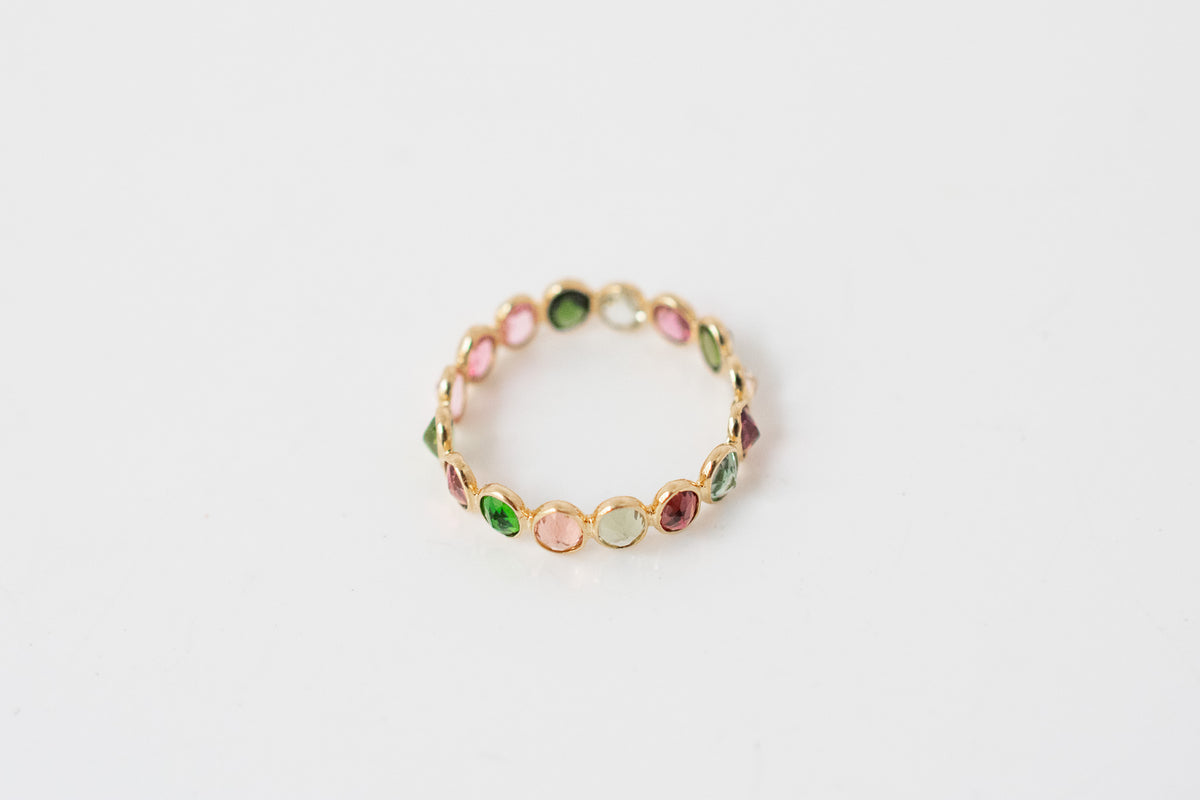 Oval-cut multicolor tourmaline gemstone eternity ring in 18K gold with bezel setting