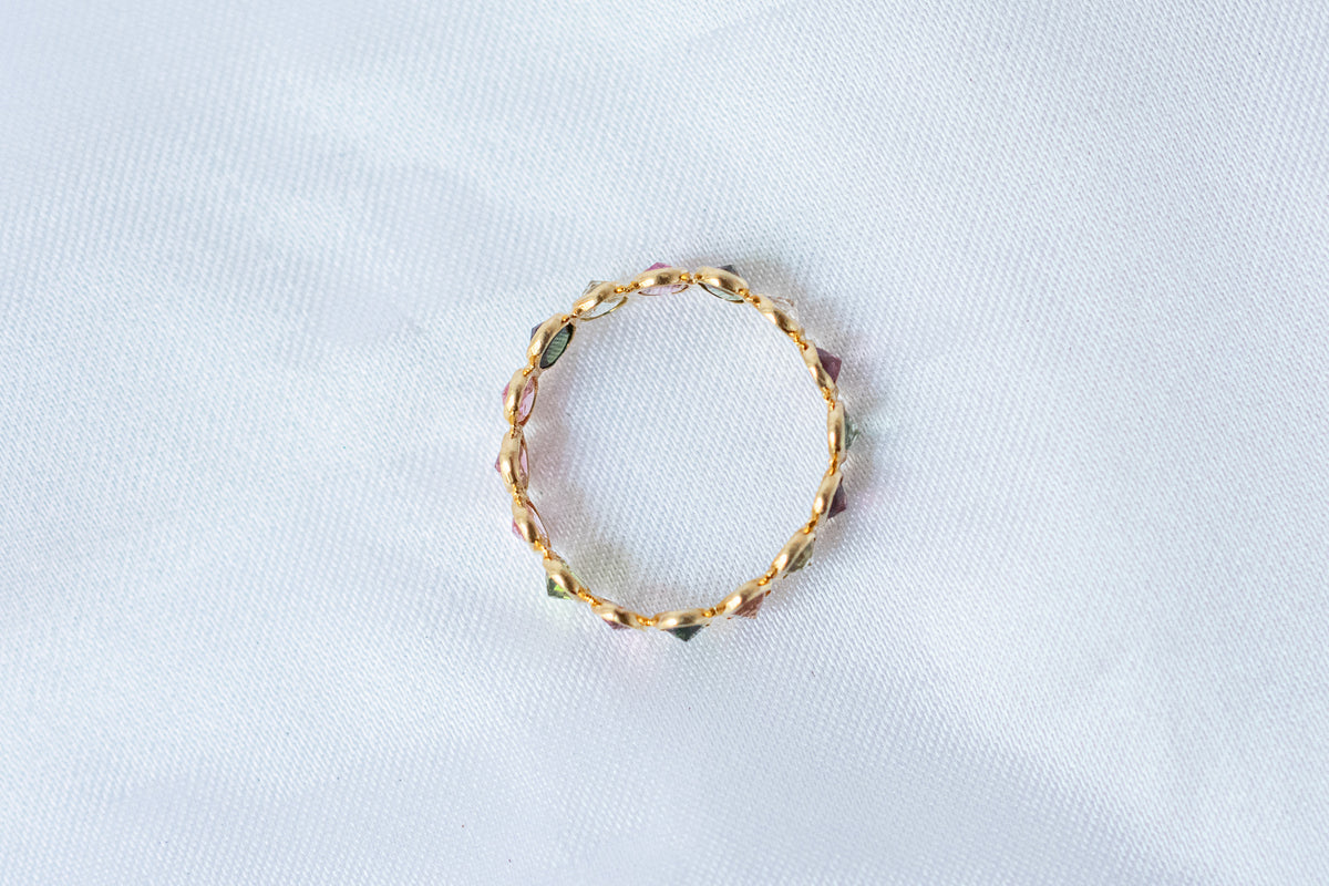 Oval-cut multicolor tourmaline gemstone eternity ring in 18K gold with bezel setting