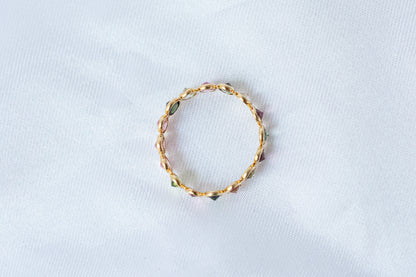 Oval-cut multicolor tourmaline gemstone eternity ring in 18K gold with bezel setting