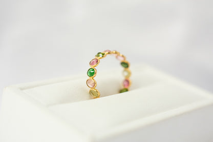 Oval-cut multicolor tourmaline gemstone eternity ring in 18K gold with bezel setting