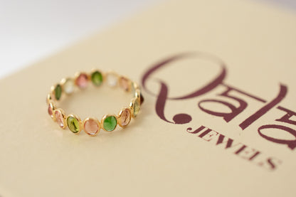 Oval-cut multicolor tourmaline gemstone eternity ring in 18K gold with bezel setting