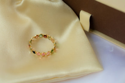 Oval-cut multicolor tourmaline gemstone eternity ring in 18K gold with bezel setting