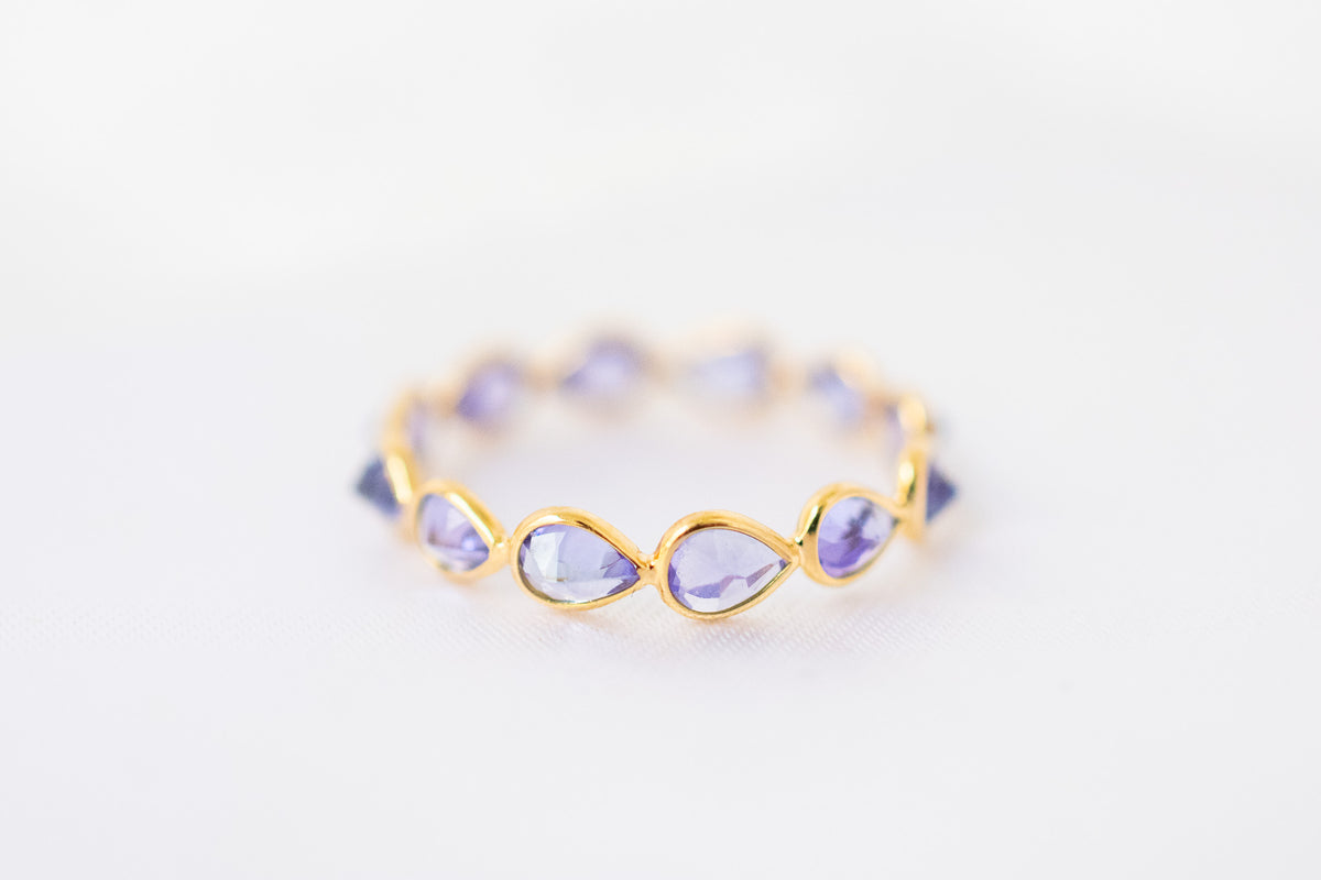 Pear-cut tanzanite gemstone eternity ring in 18K gold with bezel setting