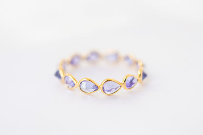 Pear-cut tanzanite gemstone eternity ring in 18K gold with bezel setting