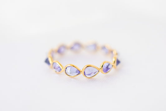 Pear-cut tanzanite gemstone eternity ring in 18K gold with bezel setting