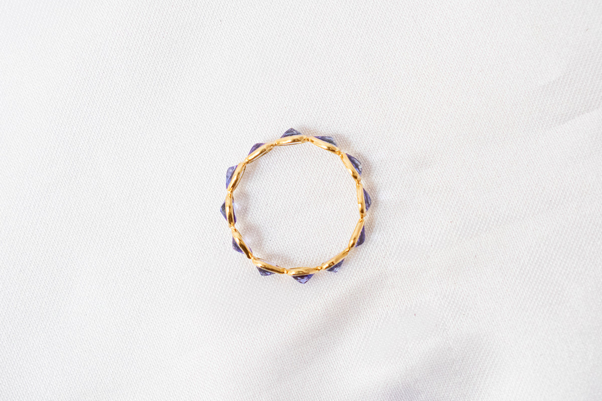 Pear-cut tanzanite gemstone eternity ring in 18K gold with bezel setting