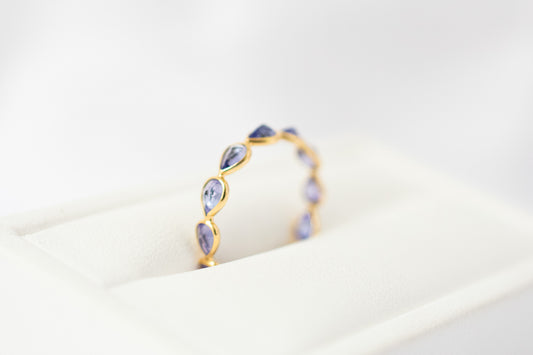 Pear-cut tanzanite gemstone eternity ring in 18K gold with bezel setting