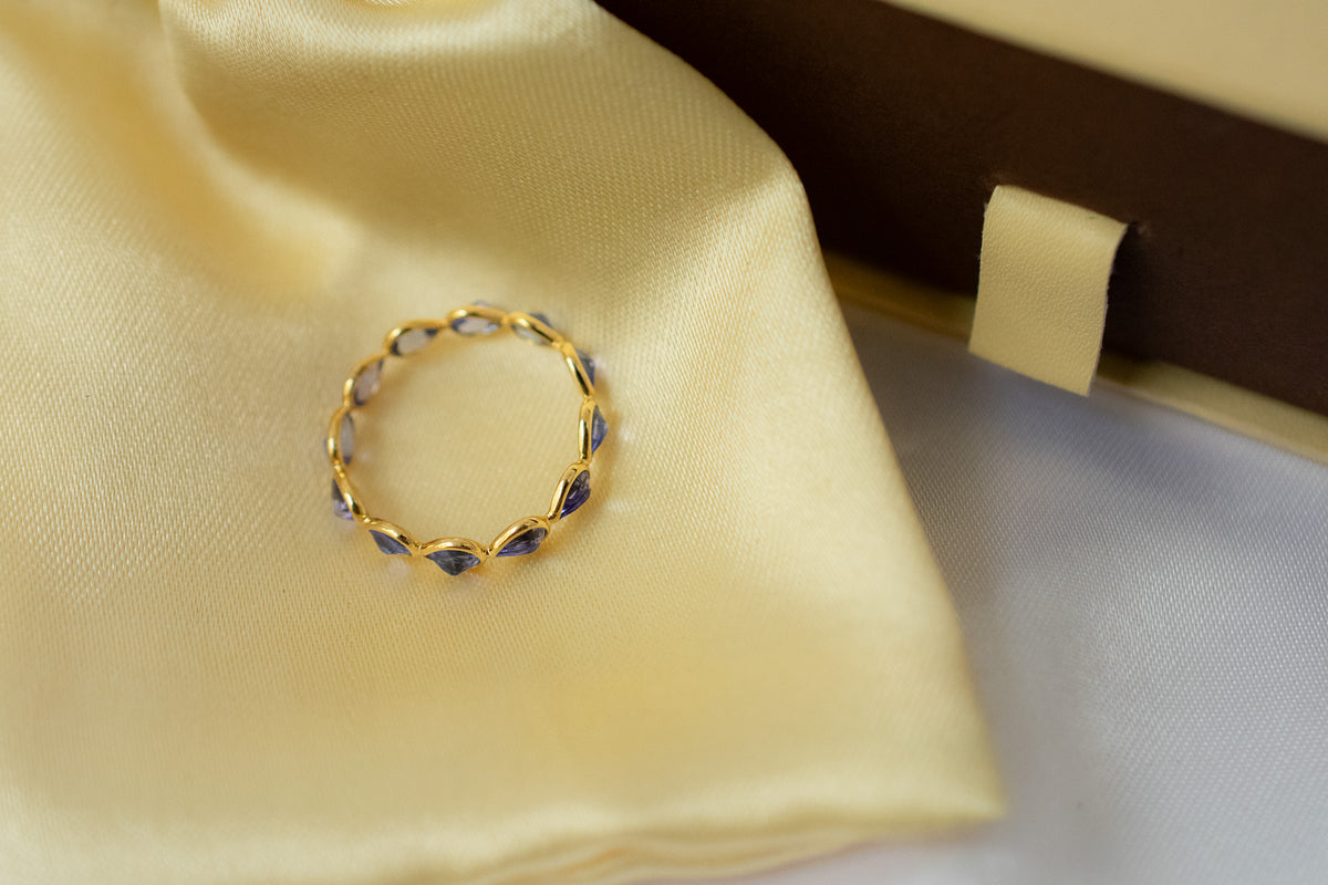 Pear-cut tanzanite gemstone eternity ring in 18K gold with bezel setting