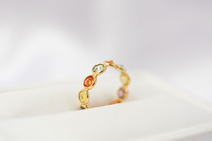 Round-cut multicolor sapphire eternity ring in 18K gold with bezel setting