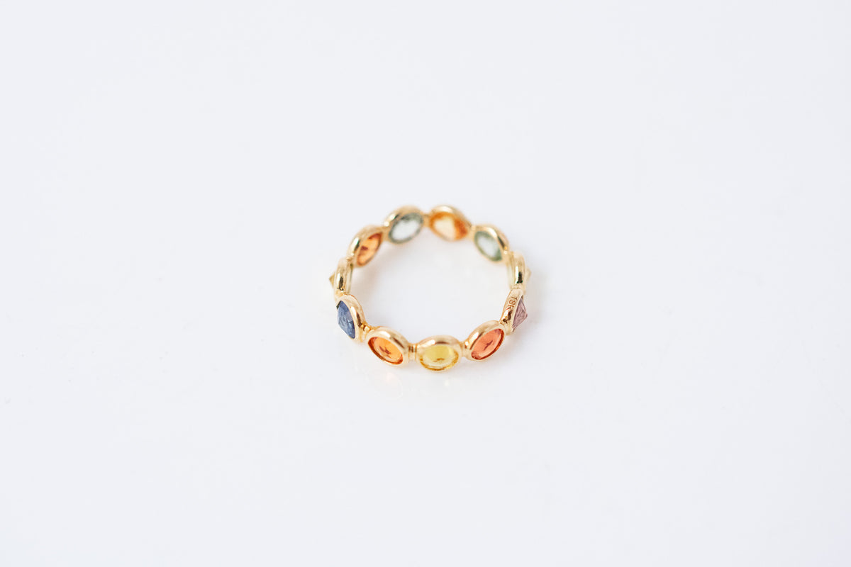 Round-cut multicolor sapphire eternity ring in 18K gold with bezel setting