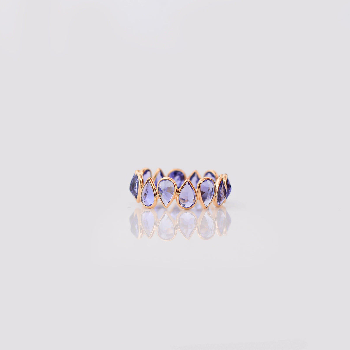 18K gold eternity ring with bezel-set pear-cut tanzanite stones