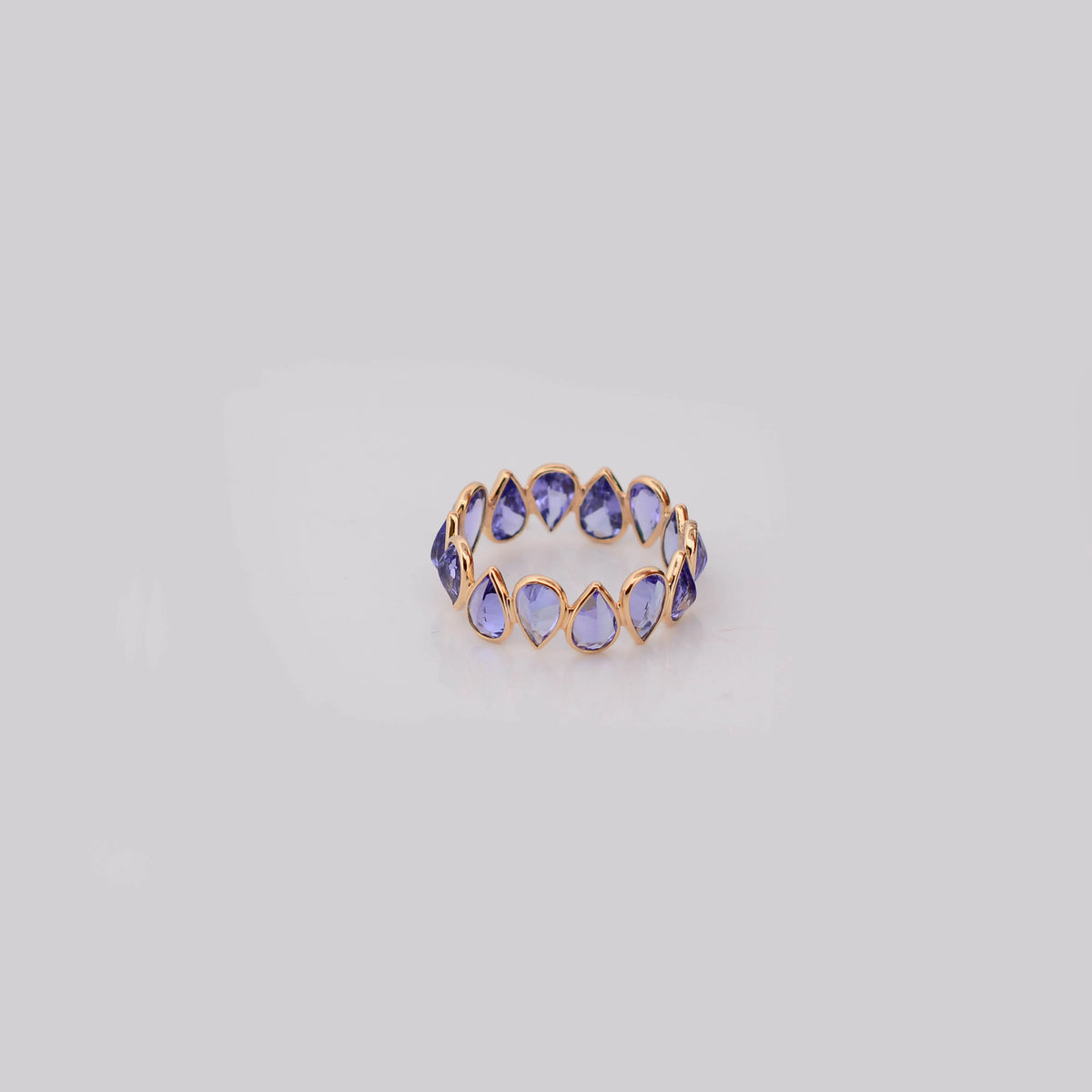 18K gold eternity ring with bezel-set pear-cut tanzanite stones