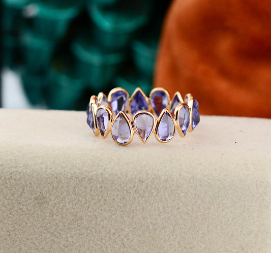 18K gold eternity ring with bezel-set pear-cut tanzanite stones