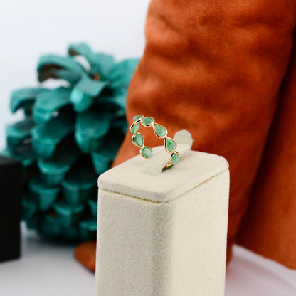 18K gold eternity ring with alternating pear-cut emeralds