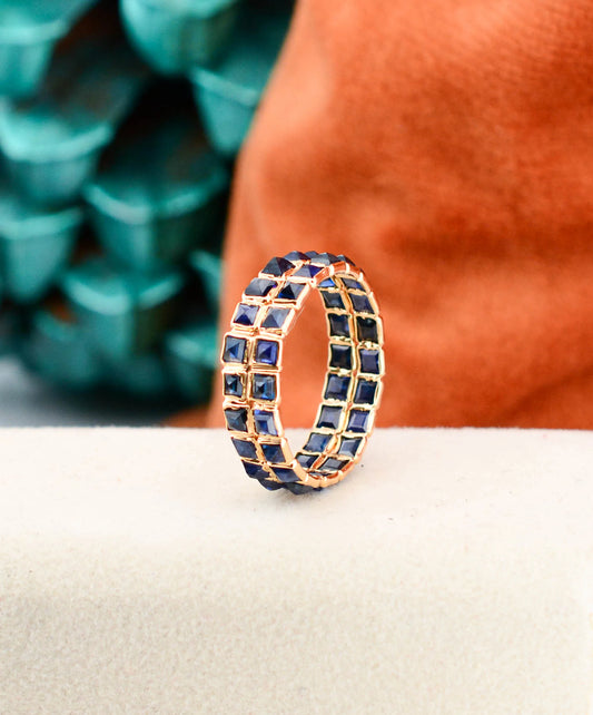 18K gold eternity ring with princess-cut blue sapphires in a channel-set grid