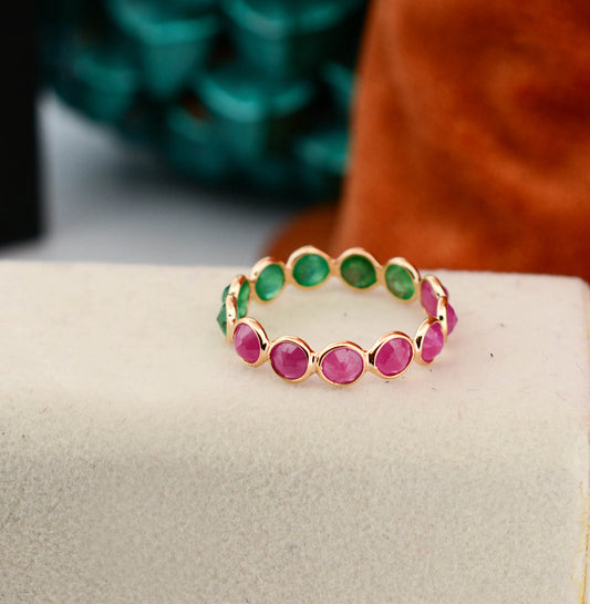 18K gold eternity ring with round-cut emerald and ruby stones in a two-tone design