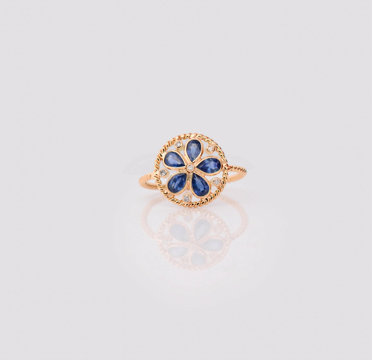 18K gold flower cluster ring with blue sapphire petals and a center diamond